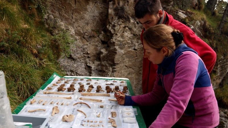 Dos arqueòlegs amb algunes de les restes extretes de la cova de Queralbs