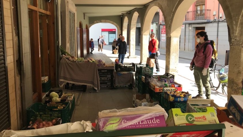 Cua de gent esperant per comprar en una fruiteria de Ripoll