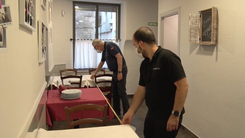 Medint la distància entre taules a l'interior dels restaurants