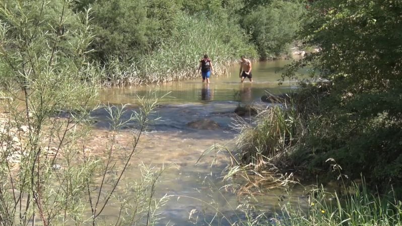 Dues persones refrescant-se a la riera de Merlès aquest cap de setmana