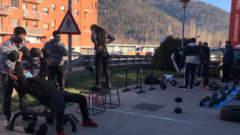Els membres del gimnàs entrenen a l'aire lliure complint les mesures de prevenció
