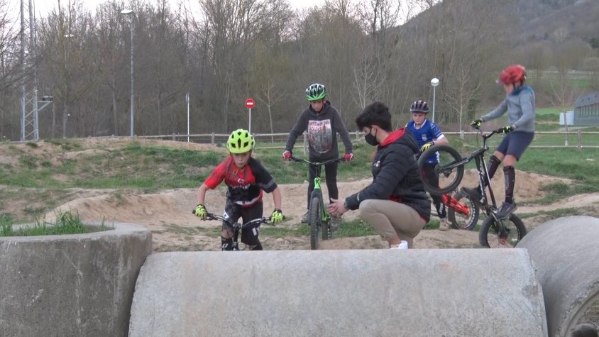 Uns pilots de l'escola intentant superar una de les zones del Bikepark de Sant Joan de les Abadesses