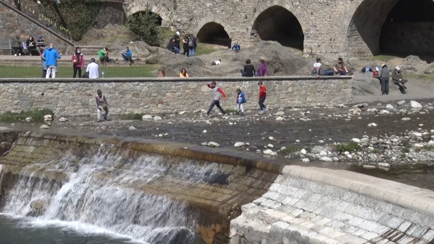 Tot de persones gaudint de l'entorn de l'emblemàtic pont de Camprodon