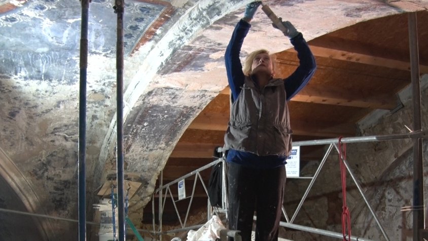 Una de les restauradores infiltra morter entre les esquerdes de l’arc més malmès de Sant Julià