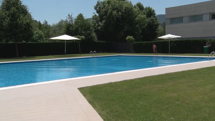 Un noi a punt de llançar-se a l'aigua en el primer dia que es va obrir la piscina de Campdevànol