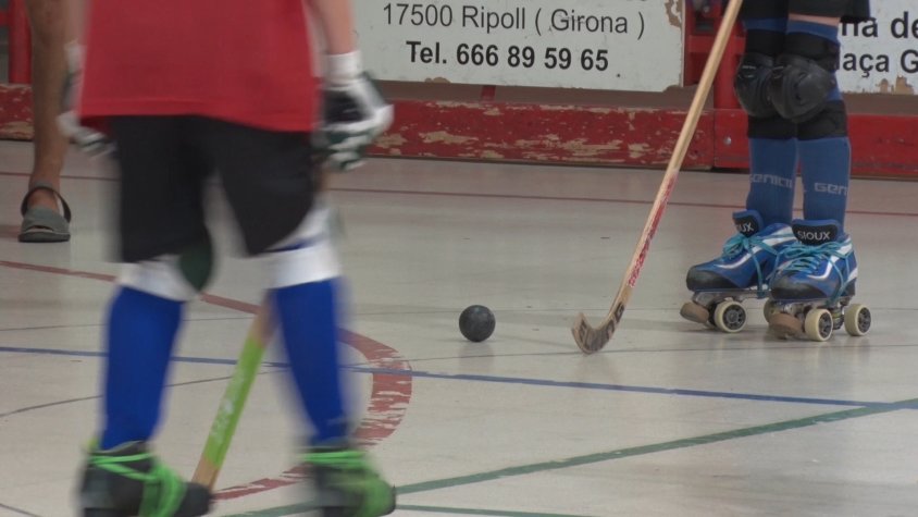 Els joves juguen a hoquei mentre es diverteixen sobre els patins