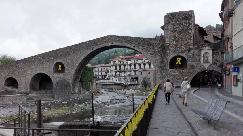 Turistes passegen sota el pont romànic de Camprodon