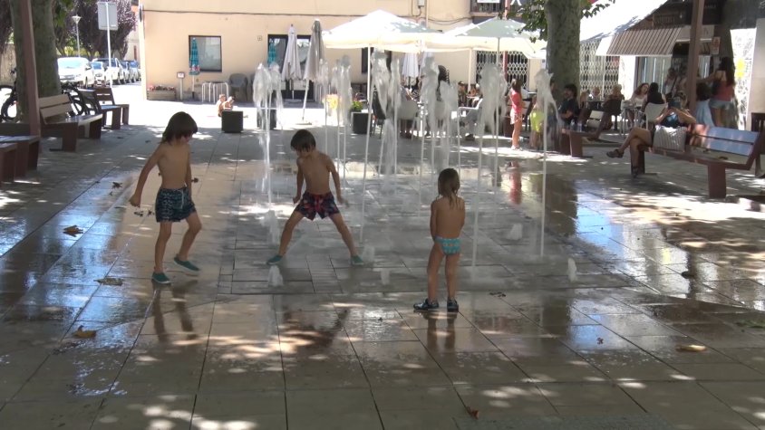 La mainada es remulla a la font de la plaça Anselm Clavé
