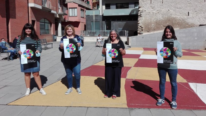 Representants de la Xarxa de Salut Mental del Ripollès sostenen el cartell commemoratiu d'enguany
