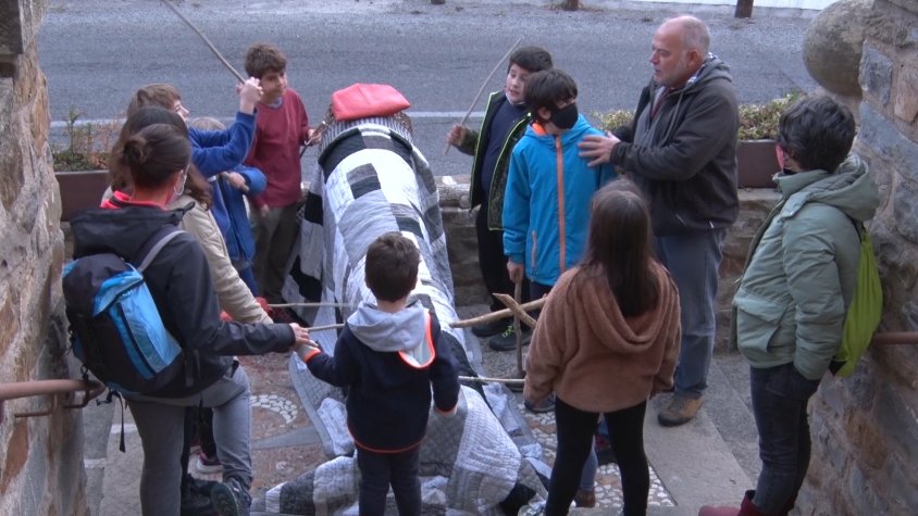 Un grup de noies i nois fent cagar el tió a Gombrèn