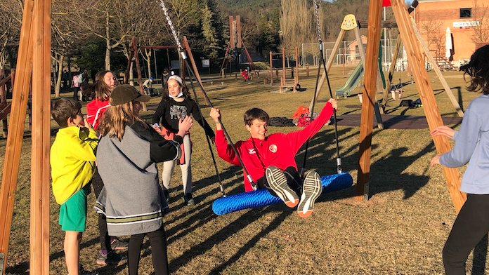Els membres del consistori juvenil, acompanyats d’altres joves de la vila, gaudeixen del nou gronxador inclusiu