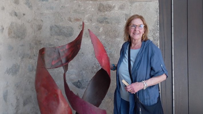 L'artista Àngels Freixanet amb la seva escultura a l'entrada del museu