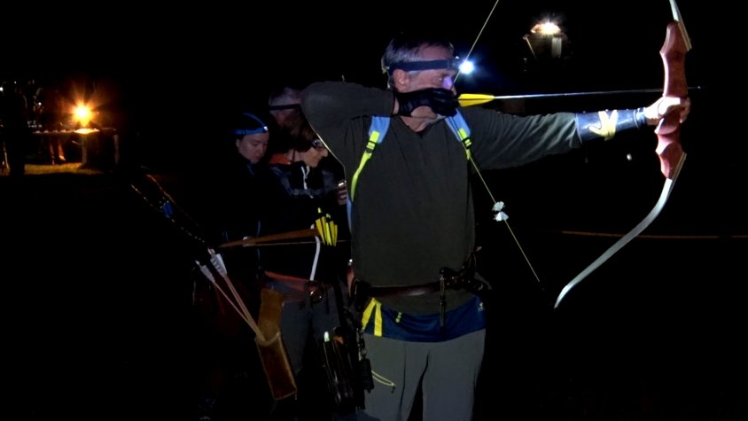 Un grup d'arquers practicant abans que comencés la competició nocturna a Pardines