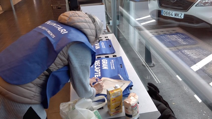 Una voluntària recull i classifica els productes en un dels supermercats