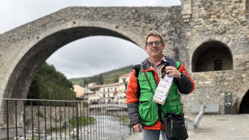 El venedor de cupons Jordi Bueno davant del pont de Camprodon