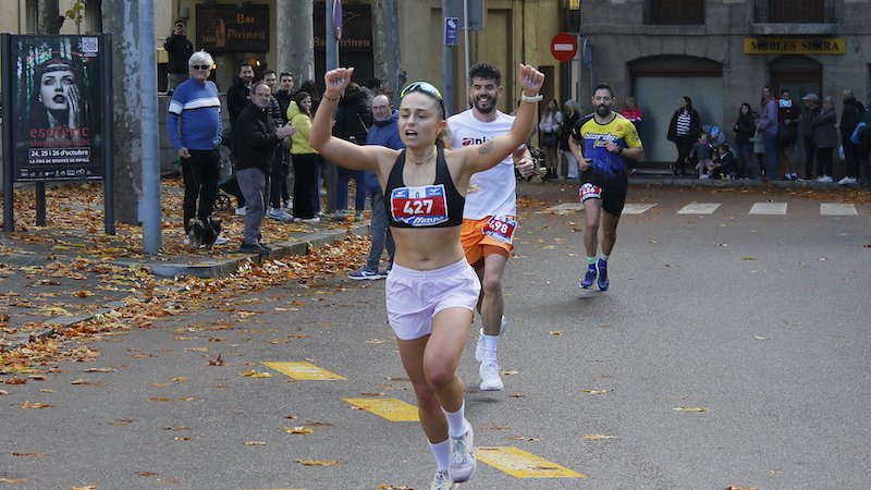 Una participant aixeca els braços abans d'acabar la cursa