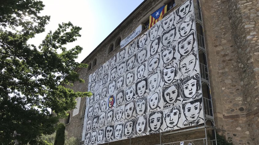 Seixanta cares de nens presideixen l'exposició a la façana de l'església